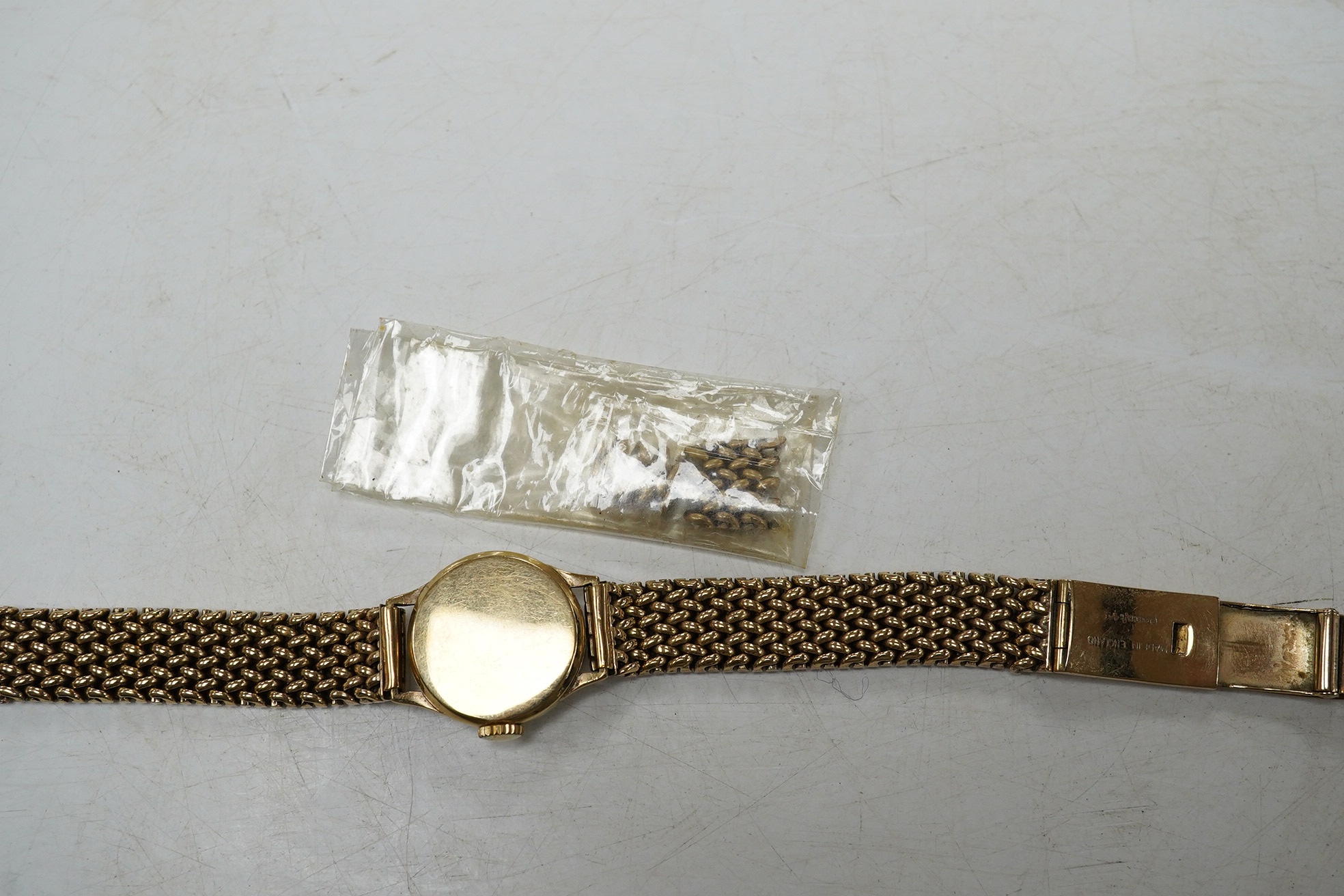 A lady's 9ct gold Omega manual wind wrist watch, on an associated 9ct bracelet, with Arabic and dot numerals, case diameter 20mm, overall length 16.7cm, gross weight 30 grams., no box or papers, with spare bracelet parts